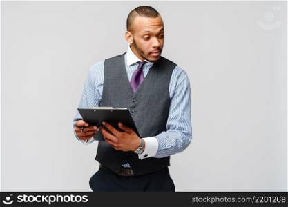 a young african american man holding plain table tablet and pen.. a young african american man holding plain table tablet and pen
