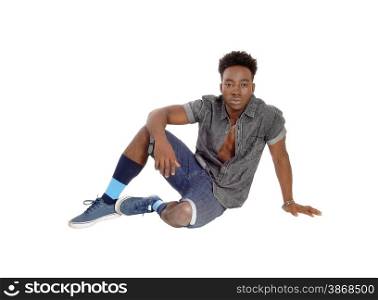 A young African American man sitting on the floor in shorts and sneakersisolated for white background.