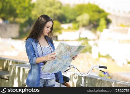 A young and beautiful female tourist searching a place on the map