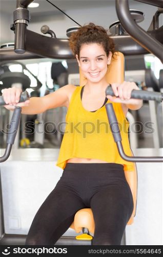 A young and beautiful woman working out at the gym
