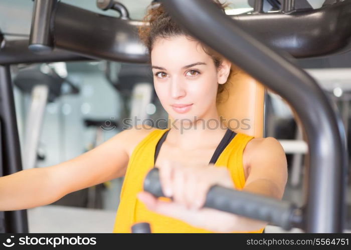 A young and beautiful woman working out at the gym