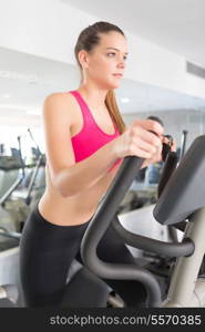 A young and beautiful woman working out at the gym