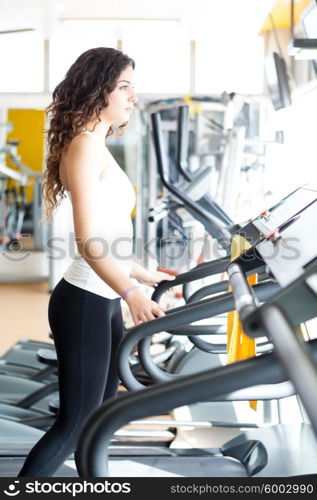 A young and beautiful woman working out at the gym