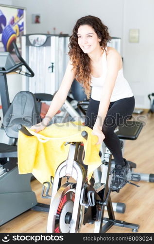 A young and beautiful woman working out at the gym