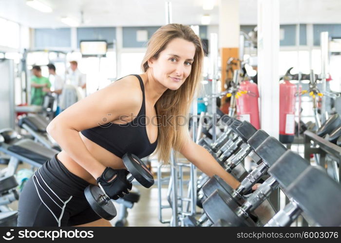 A young and beautiful woman working out at the gym