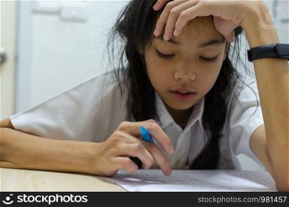A young asian schoolgirl sitting in a stressful room from homework