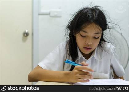 A young asian schoolgirl sitting in a stressful room from homework