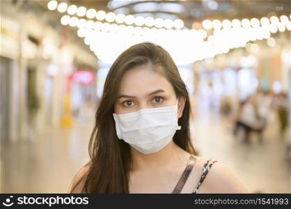 A young Asian woman is wearing protective mask shopping in shopping center, Coronavirus protection,New normal lifestyle concept.. A young Asian woman is wearing protective mask shopping in shopping center, Coronavirus protection,New normal lifestyle concept