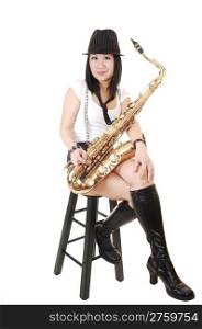 A young Asian woman sitting in the studio, playing the saxophone inshorts with suspender and a hat on her black hair, for white background.