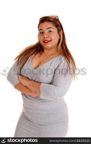 A young Asian women in a gray dress with her arms crossed standingisolated for white background.