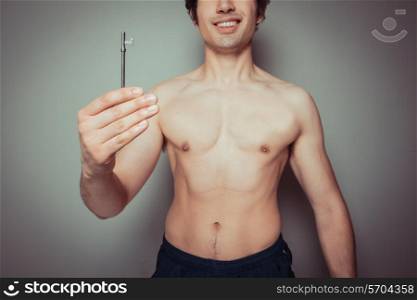 A young athletic man is holding a key