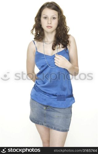 A young attractive female model in blue top and denim skirt