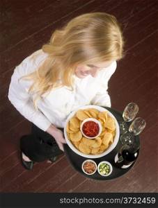 A Young Attractive Female Server Brings Wine and Appetizer Food Tray