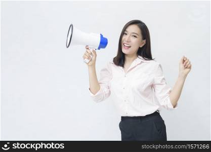 A young beautiful Asian woman is announcing by megaphone on white background .. A young beautiful Asian woman is announcing by megaphone on white background