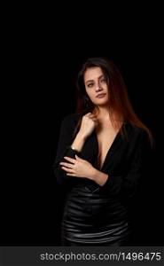 a young beautiful dark haired woman in a black unbuttoned shirt that revealed her Breasts and a black leather skirt on a black isolated background.