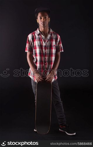 A young black skater posing in studio