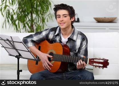 A young boy learning guitar.
