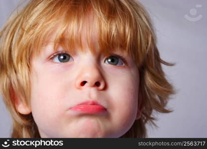 a Young boy pouts at the camera