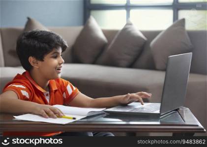A YOUNG BOY USING LAPTOP TO ATTEND ONLINE CLASS