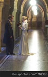 A young bride and groom in the hallway of a church