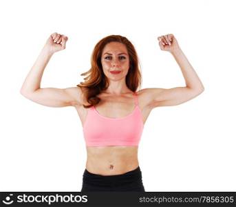 A young brunette woman in a portrait picture in a pink sports bra, showingher muscles, isolated on white background.