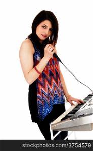 A young brunette woman playing the keyboard and singing, isolated for white background.
