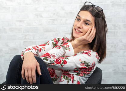 a young brunette woman resting on the armchair