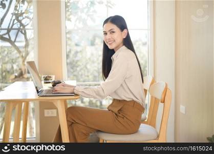 A young business woman working with her laptop in coffee shop. Young business woman working with her laptop in coffee shop