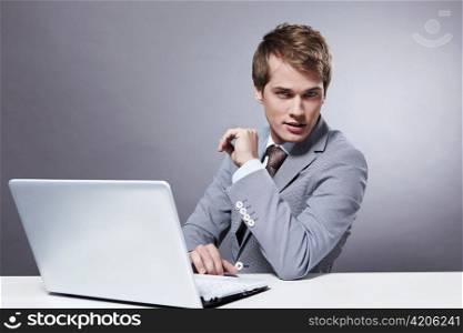 A young businessman at the table with a laptop