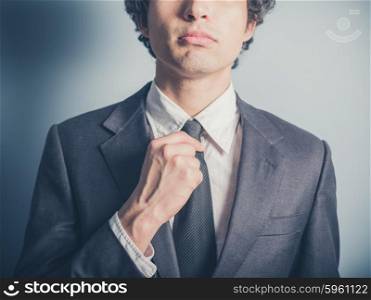 A young businessman his adjusting his tie