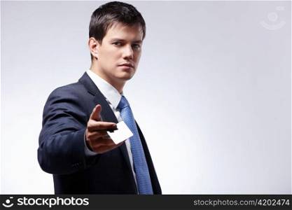 A young businessman holds out a business card