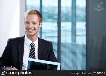 A young businessman in a suit in the office