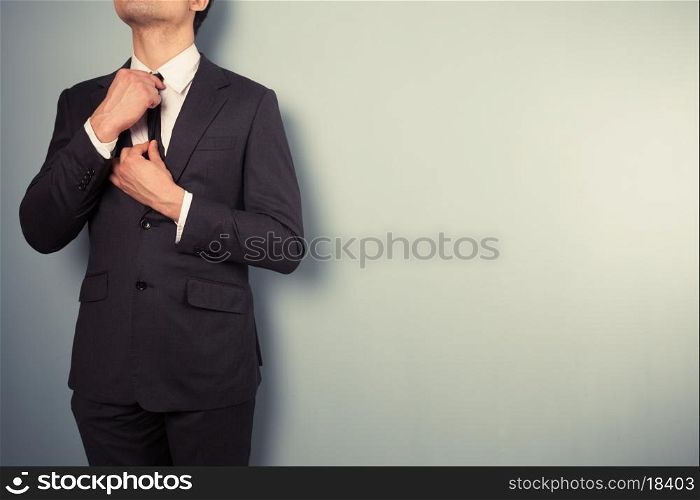 A young businessman is adjusting his tie