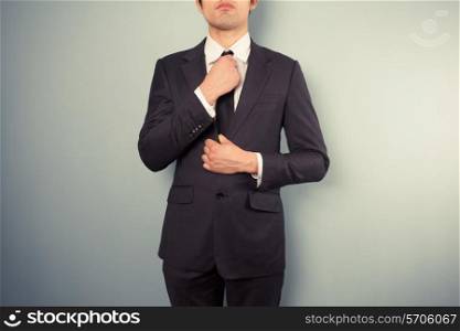 A young businessman is adjusting his tie