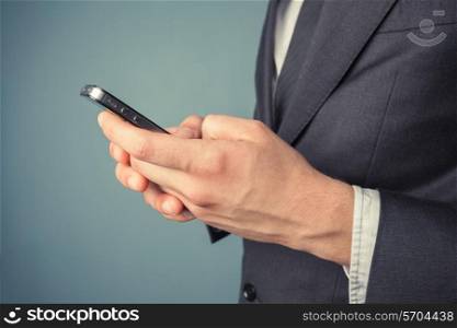 A young businessman is using his smart phone