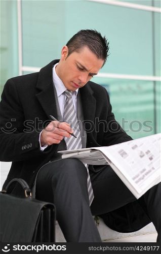 a young businessman looking newspaper