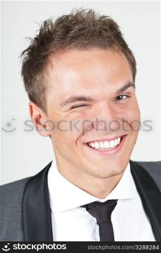 A young businessman, looking satisfied, giving a wink
