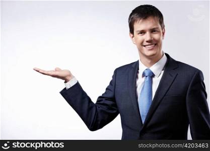 A young businessman shows his hand towards