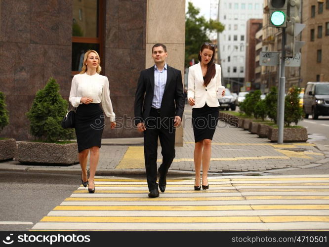 A young businessman walking on the street with their secretaries, outdoor summer street