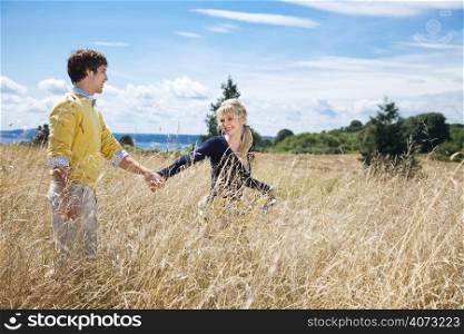 A young caucasian couple in love having fun on a grassy field