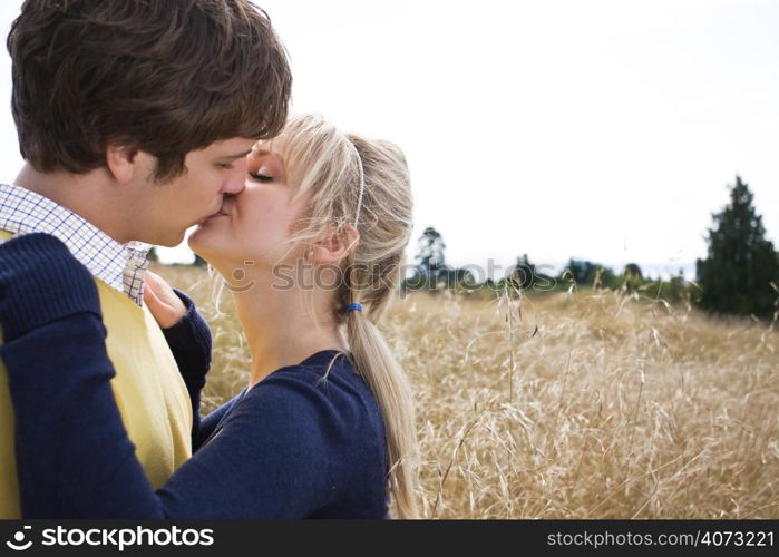 A young caucasian couple in love kissing outdoor