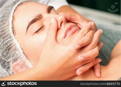 A young caucasian woman getting facial massage in a spa. A young caucasian woman getting facial massage in a spa.