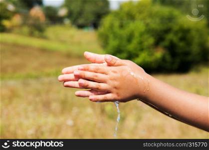 A young child is washing his hand.