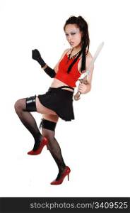 A young Chinese woman in a short black skirt, black stockings and clovesdancing in the studio in red high heels, on white background.