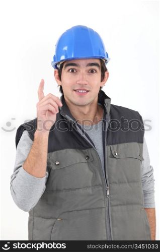 A young construction worker raising his finger.
