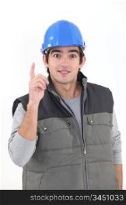 A young construction worker raising his finger.