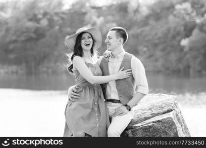 a young couple a guy and a girl are walking near a mountain lake surrounded by granite rocks