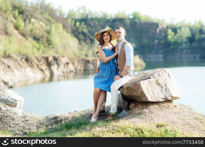 a young couple a guy and a girl are walking near a mountain lake surrounded by granite rocks