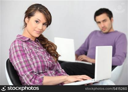 a young couple doing computer