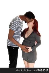 A young couple kissing and holding the hand on her tummy, standing in profile, isolated for white background.